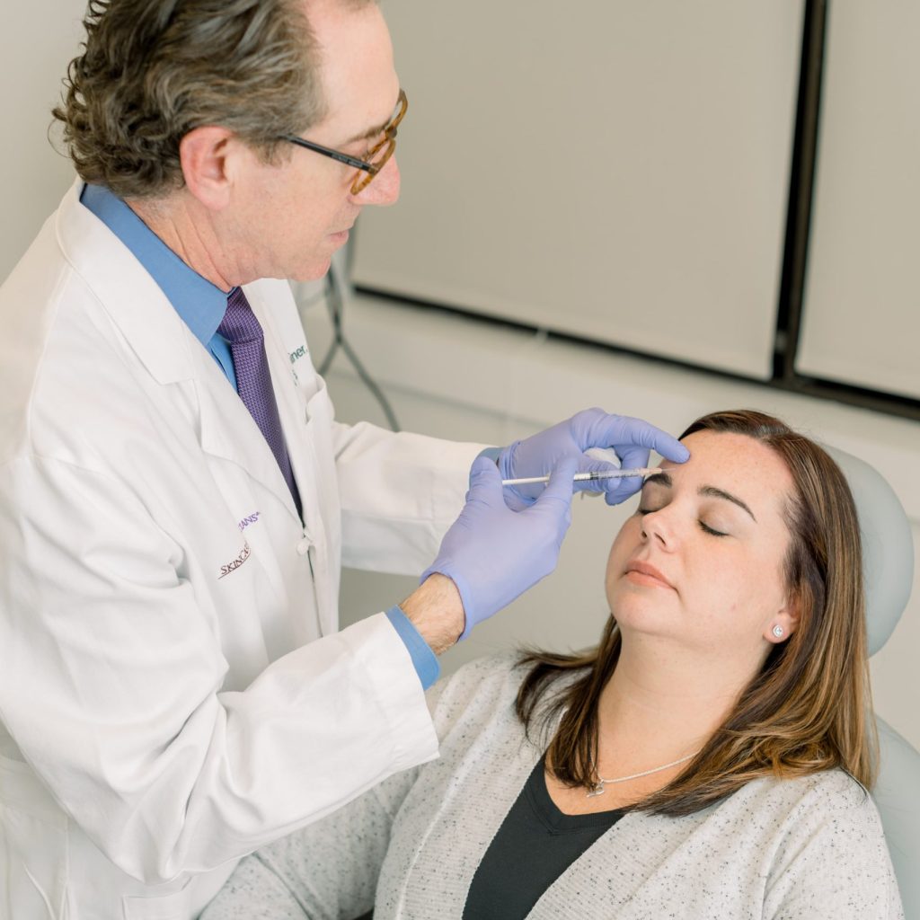 D. Kaminer injecting Botox on patient's forehead