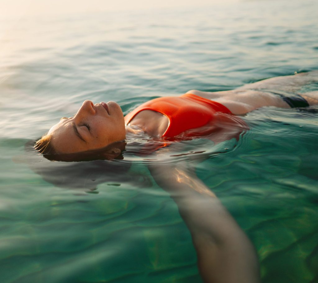 A woman is swimming outside